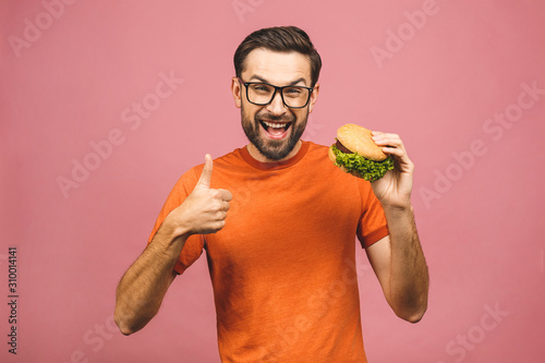 Bild auf Leinwand Young man holding a piece of hamburger