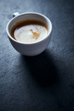 Cup of coffee on dark stone background. Copy space
