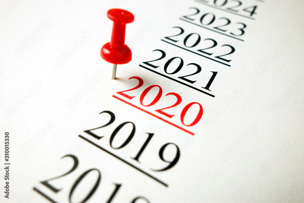 Number 2020 written on paper with pushpin Number 2020 written on paper with pushpin