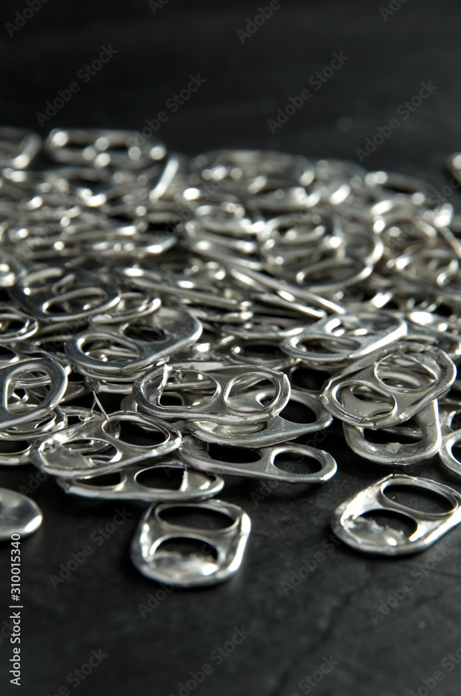 Recycling Beer and Pop Can Aluminum Tabs on Black Background