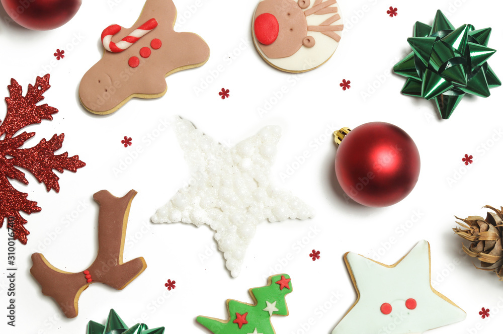 Naklejka premium Festive winter background. Red Christmas ornaments and gingerbead cookies isolated on white background. Christmas, winter holiday, new year concept.