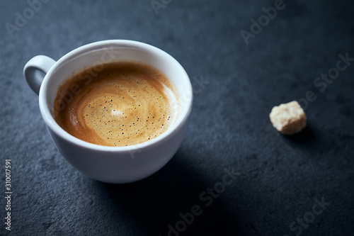 Cup of coffee on dark stone background. Close up. 