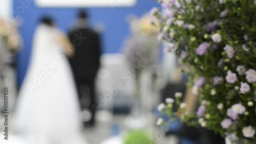 Wallpaper Mural Beautiful bouquet of flowers with the bride and groom marrying in the background, Father performing the union of the couple, until death do them part. Pan capture. Torontodigital.ca