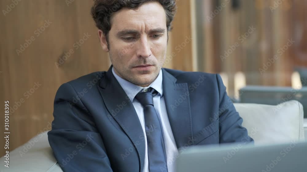 Businessman connected on laptop in hotel lounge Businessman connected on laptop in hotel lounge