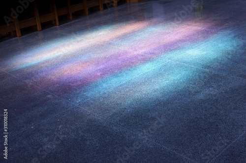 Light shining through blue stained glass windows projected on the floor of a church
