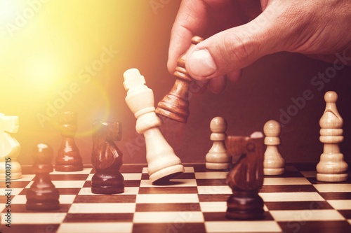 Human hand playing chess, buisness strategy concept