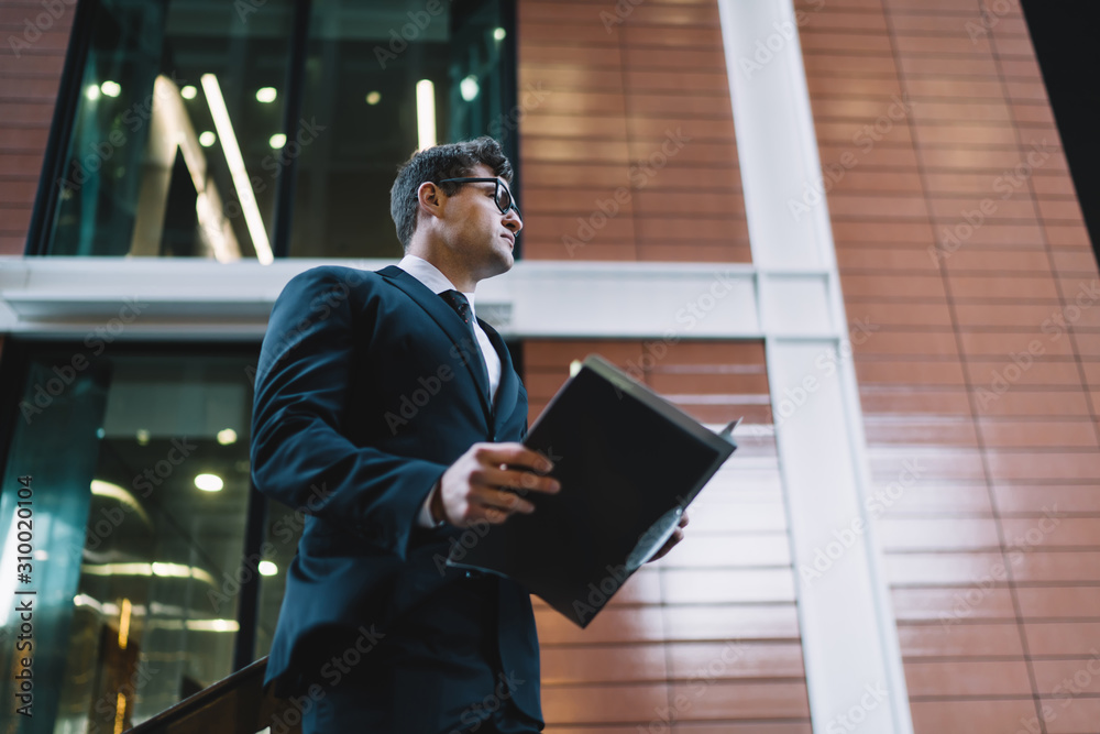 Contemporary formal man with paper file
From below of elegant man in glasses holding file with papers while standing on background of contemporary city building looking away Contemporary formal man with paper file
From below of elegant man in glasses holding file with papers while standing on background of contemporary city building looking away