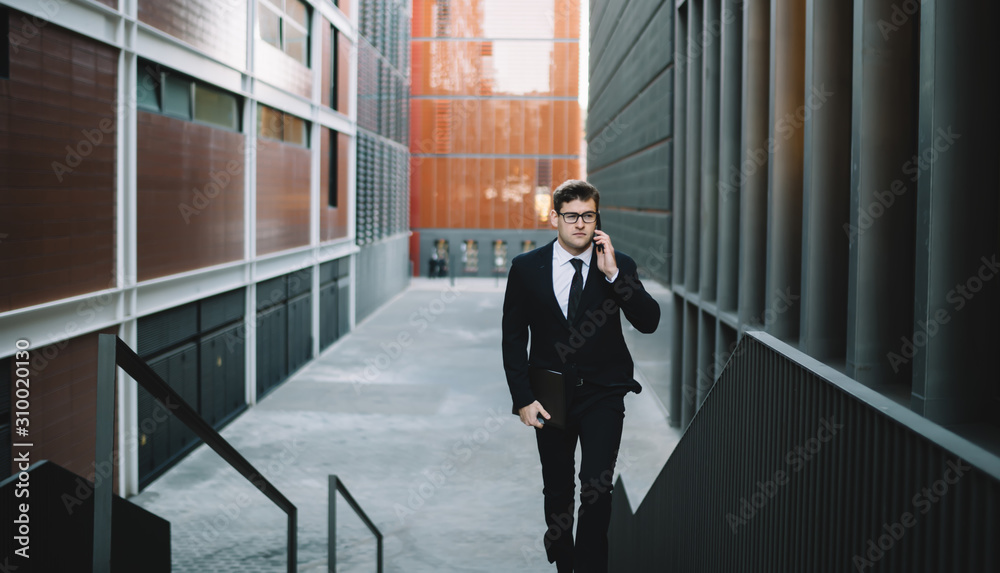 Young employee speaking on phone on street
Contemporary formal man in suit carrying file with papers and talking seriously on mobile phone walking on stairs on urban background Young employee speaking on phone on street
Contemporary formal man in suit carrying file with papers and talking seriously on mobile phone walking on stairs on urban background