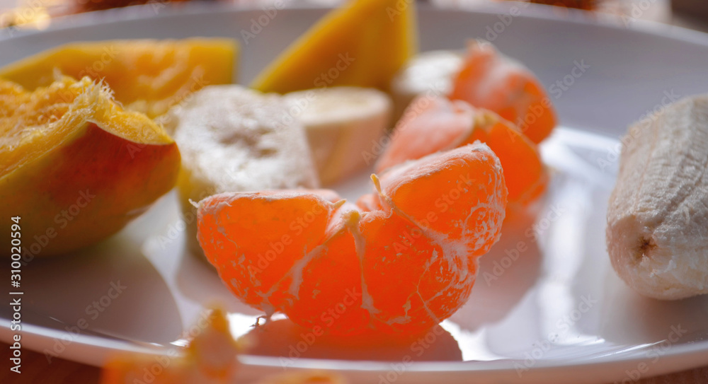 Juicy tangerines and tropical fruits on the New Year's table. On a wooden background. Juicy tangerines and tropical fruits on the New Year's table. On a wooden background.