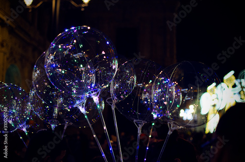 Selective focus on LED balloons with Christmas decorations in the background in Plaza San Francisco, Seville, Spain