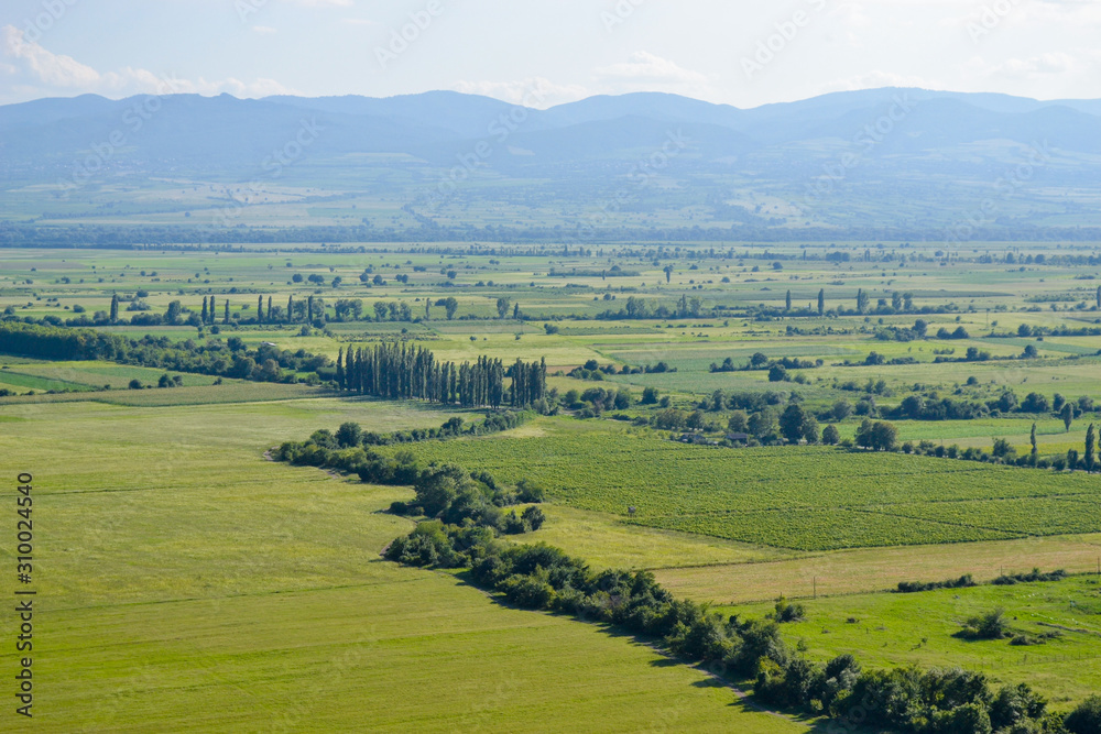 Alazani Valley with its fields and vineyards in Kvareli, a view from a road leading from the plain to Nekresi Monastery. Kakheti Region, Georgia.