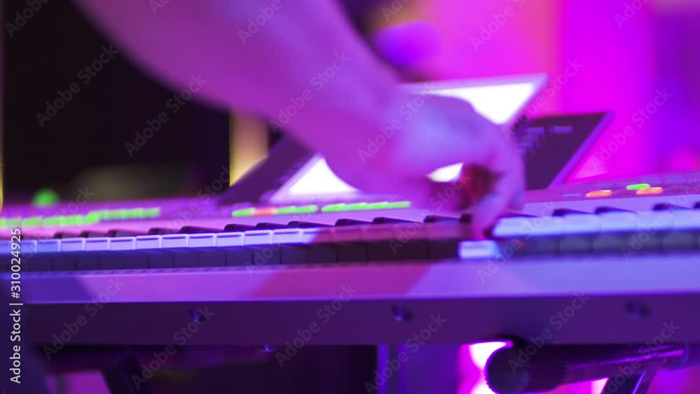 Musician play on the synth in club, slow motion and close up. Purple light. Musician play on the synth in club, slow motion and close up. Purple light.