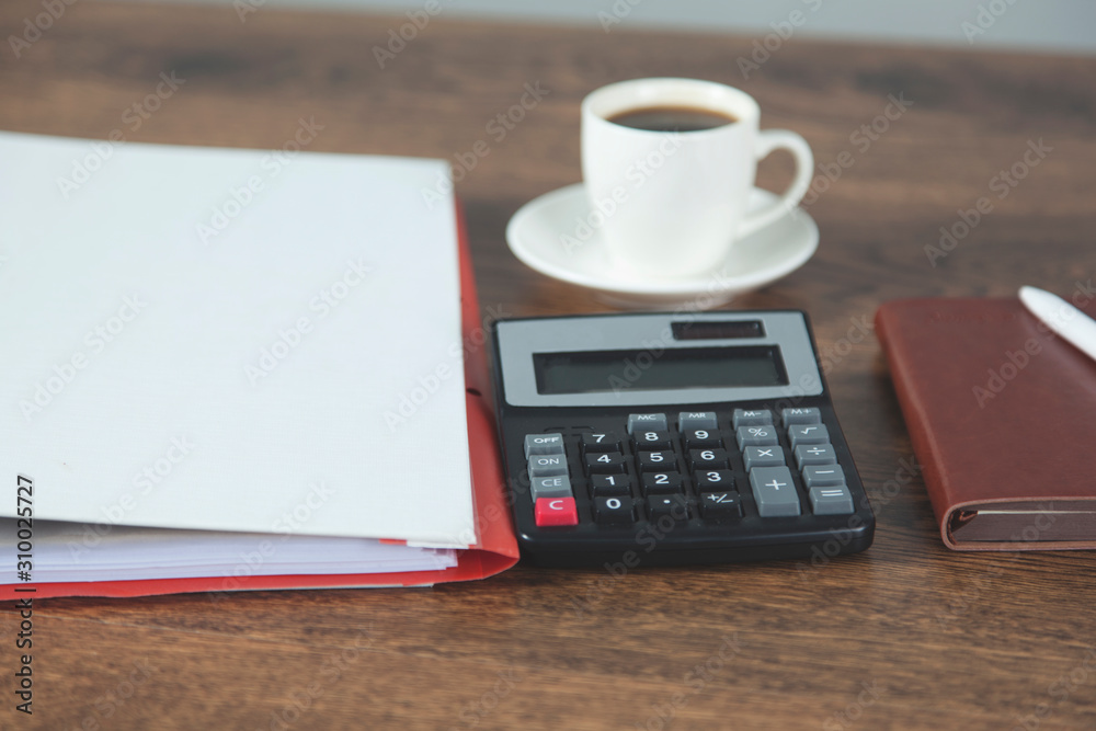 calculator with cupof coffee on desk calculator with cupof coffee on desk
