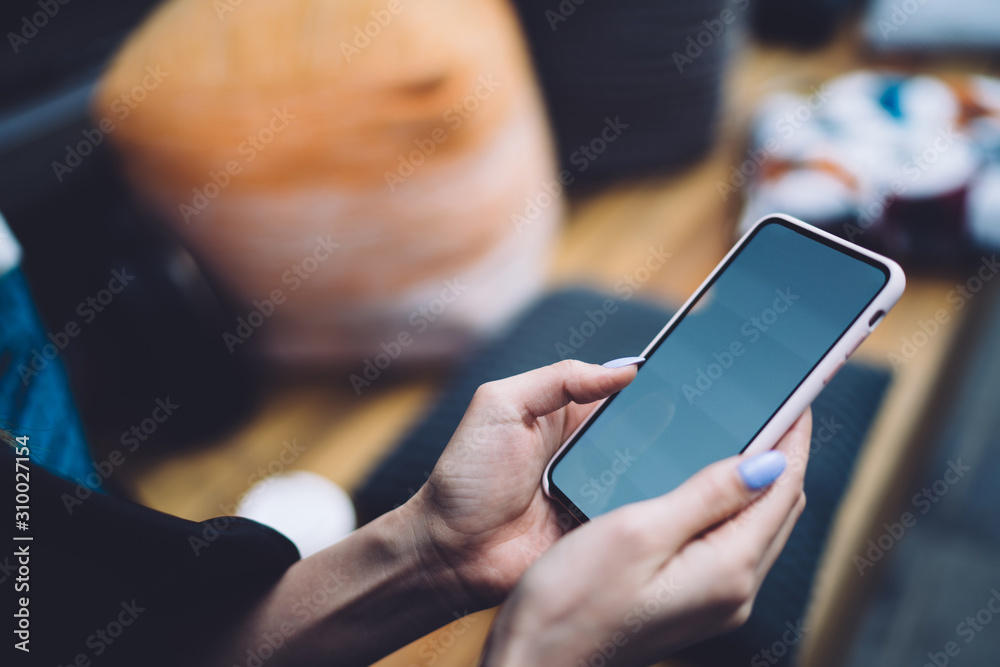 Faceless female showing smartphone screen