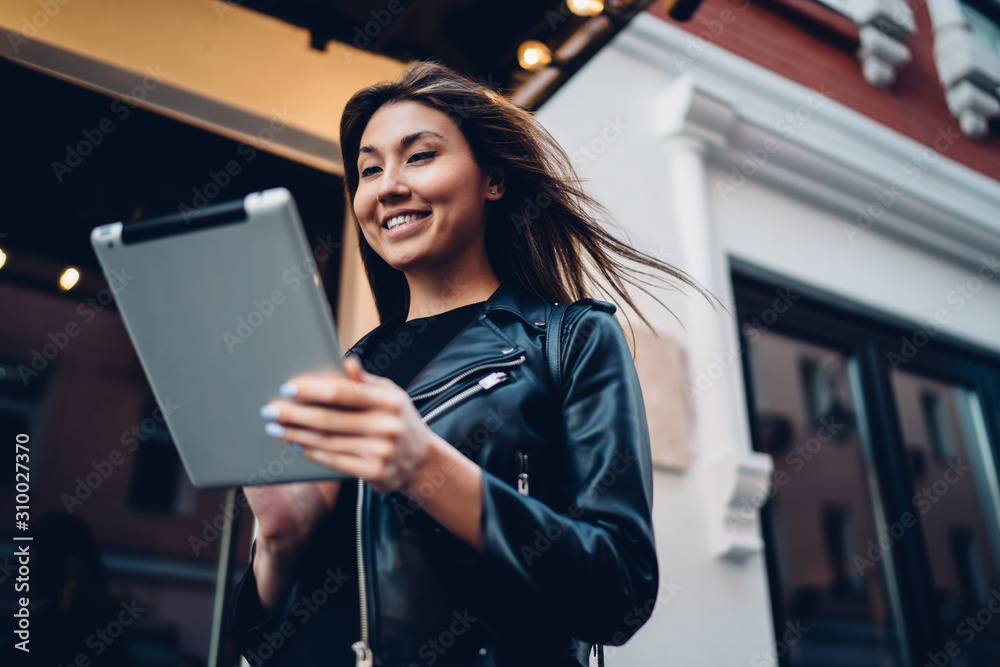 Cheerful female browsing tablet on street Cheerful female browsing tablet on street