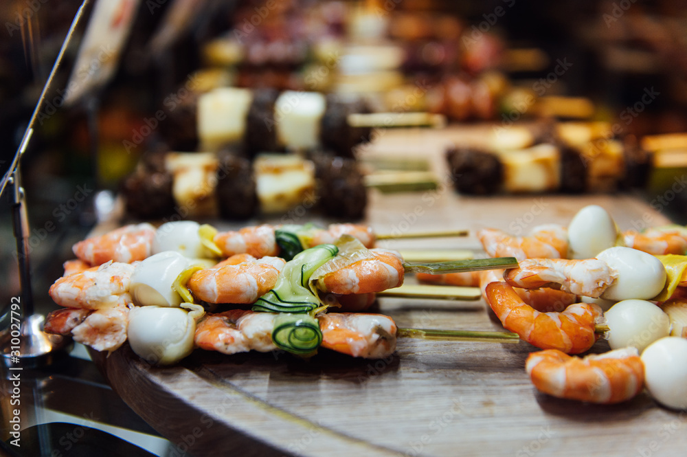 Obraz premium A wide variety of traditional tapas with seafood in Spain at the San Miguel market