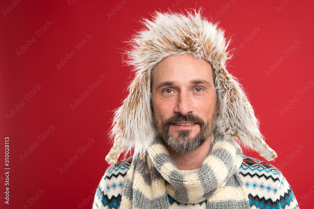 Hipster fashion winter accessories. Mature handsome hipster with beard and  mustache like to wear unusual things. In his own style. Man bearded hipster  wear furry hat striped scarf and knitted sweater Stock
