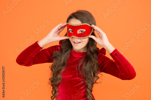Incognito mode. Kid wear eye mask. Girl wear mask orange background. Winter event and entertainment. Child development. Visit public event anonymously. Winter new year party. Winter carnival