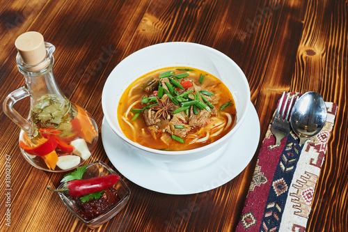 Oriental Lagman Uzbek soup on a wooden table. photo