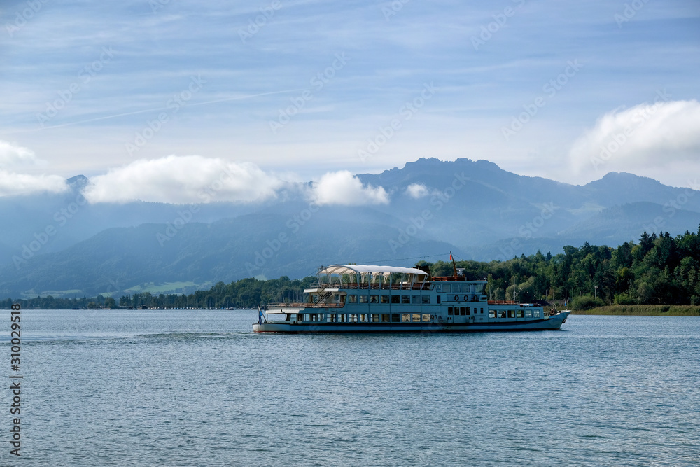 Dawn on Chiemsee Lake. In the foreground is a pleasure boat. Bavaria, Germany Dawn on Chiemsee Lake. In the foreground is a pleasure boat. Bavaria, Germany
