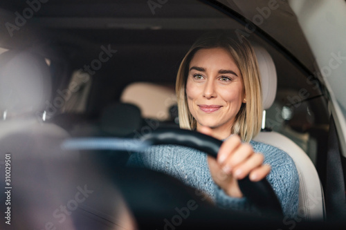 Portrait of smiling young woman driving a car photo