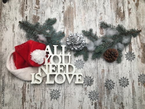 All you need is love logo with Christmas theme on wood background with Santa hat. photo