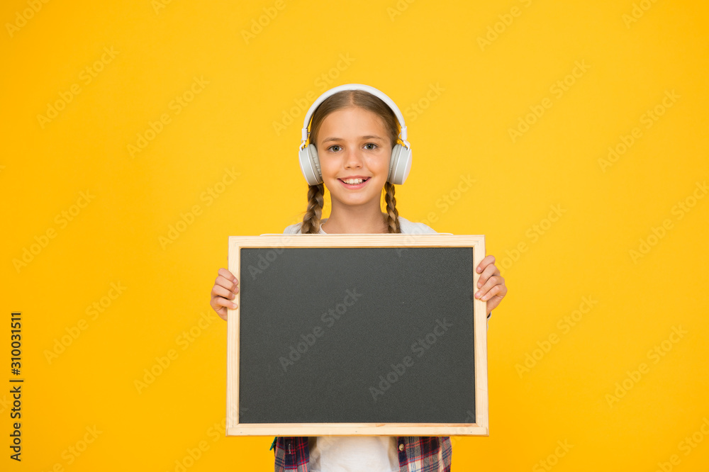 hipster girl hold empty blackboard. schoolgirl casual style show information. school mart shopping. music in her headphones. child presenting project. welcome to our modern school. Dream big hipster girl hold empty blackboard. schoolgirl casual style show information. school mart shopping. music in her headphones. child presenting project. welcome to our modern school. Dream big