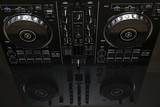 DJ controller or mixer with reflection on the background with copy space for text. DJ equipment. Music background or banner, card. Modern technologies.