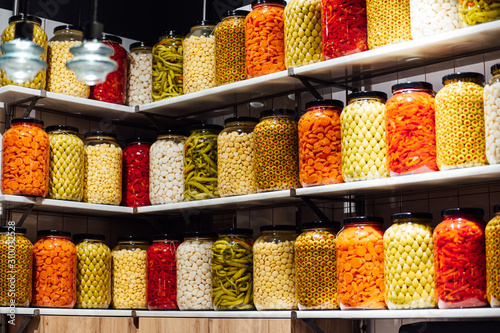 Vászonkép Various jars with Home Canning Fruits and Vegetables jam on glass shelves
