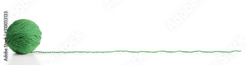 Fotografie A ball of green yarn with a long thread