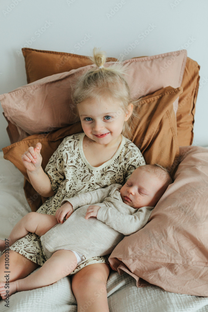 Girl with newborn sibling on bed Girl with newborn sibling on bed