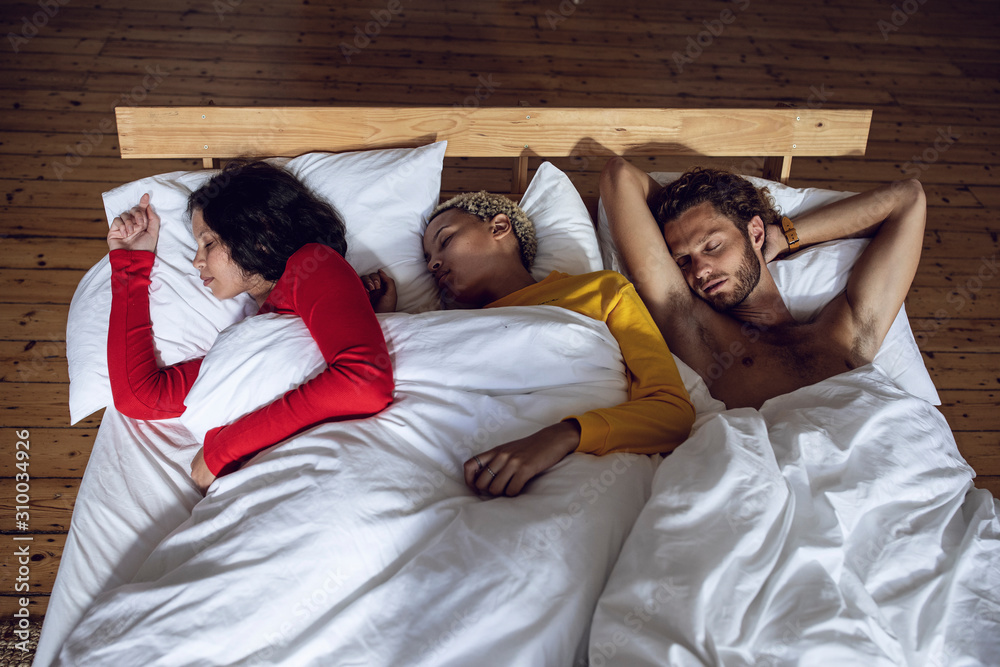Three friends sleeping in bed at home Stock Photo Adobe Stock