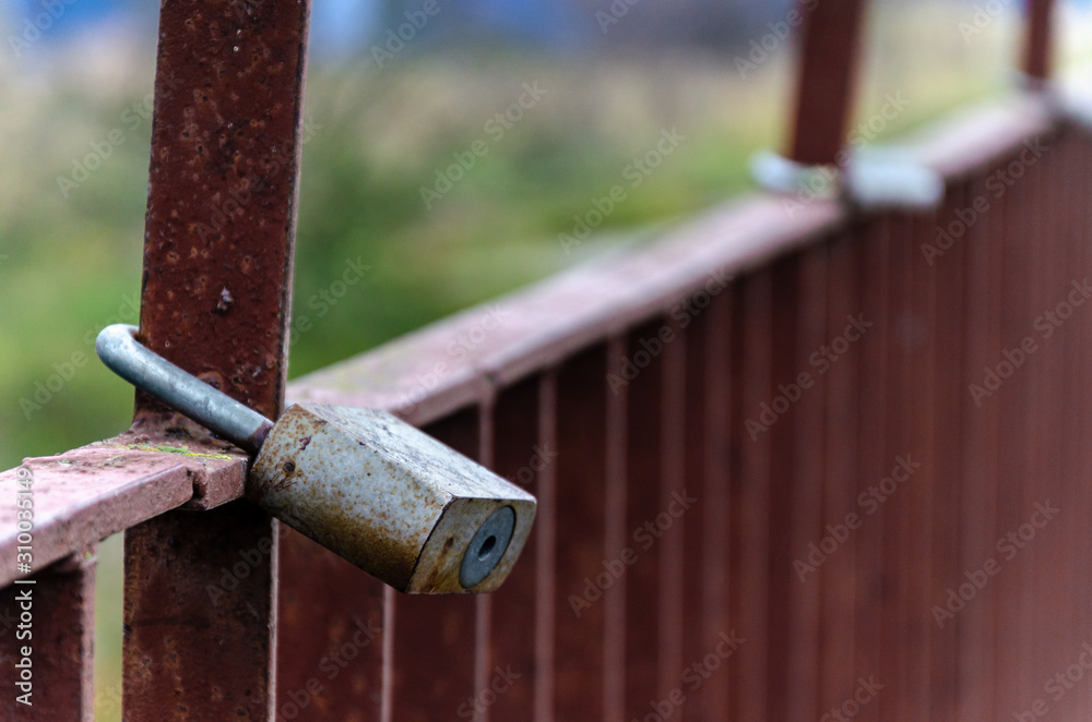 padlock on a metal fence. background red. old rusty fence. Love and harmony for life. amulet from evil. padlock on a metal fence. background red. old rusty fence. Love and harmony for life. amulet from evil.