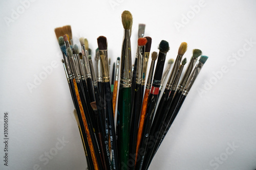 Set of paint brushes on light wall background. Place for text.