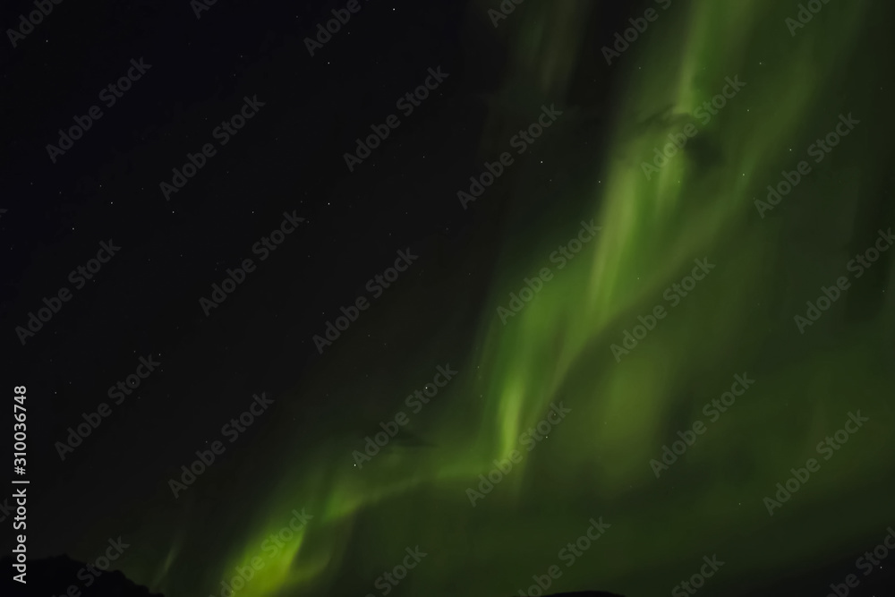 Aurora borealis in night northern sky. Ionization of air particles in the upper atmosphere.