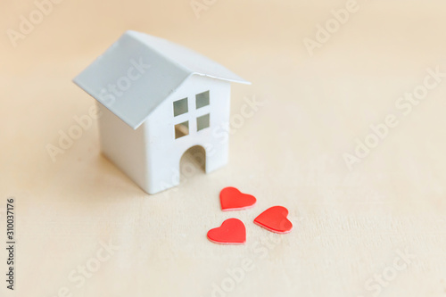 Miniature toy model house with red heart on wooden backdrop. Eco Village abstract environmental background. Real estate mortgage property insurance sweet dream home ecology concept photo