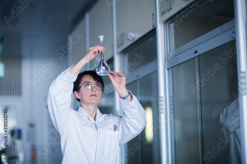 Female chemist at work examining a liquid