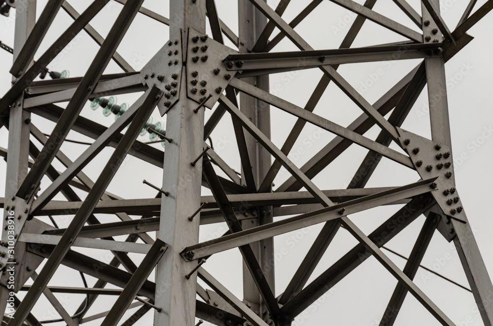 Cables and modular suspension insulators for overhead power line. Transmission tower. Metal construction. The sky in the fog, gray gloomy day. Industry as a cause of environmental pollution. Cables and modular suspension insulators for overhead power line. Transmission tower. Metal construction. The sky in the fog, gray gloomy day. Industry as a cause of environmental pollution.