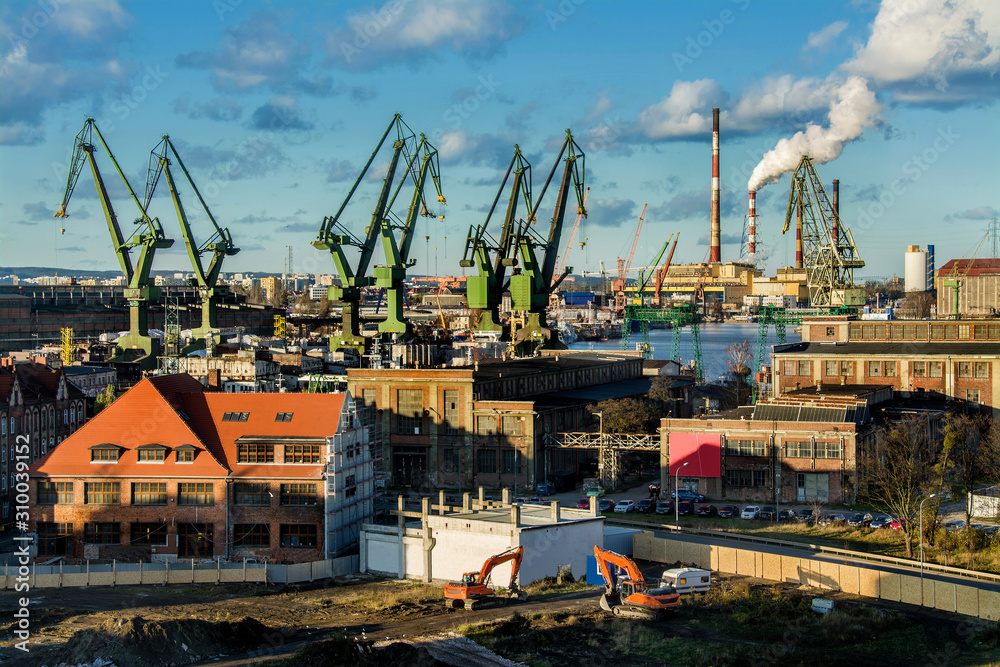 View of the shipyard and port - industry part of the city of Gdansk (Gdańsk) with shipyard constructions and cranes. Poland