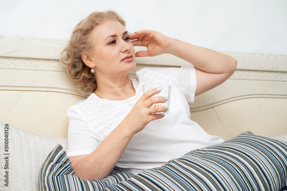 A fifty-year-old woman feels the symptoms of menopause. She feels bad because of menopause. Hot flashes, sweating, dizziness, irritability. Menopause concept. Harmonious restructuring of the body. A fifty-year-old woman feels the symptoms of menopause. She feels bad because of menopause. Hot flashes, sweating, dizziness, irritability. Menopause concept. Harmonious restructuring of the body.