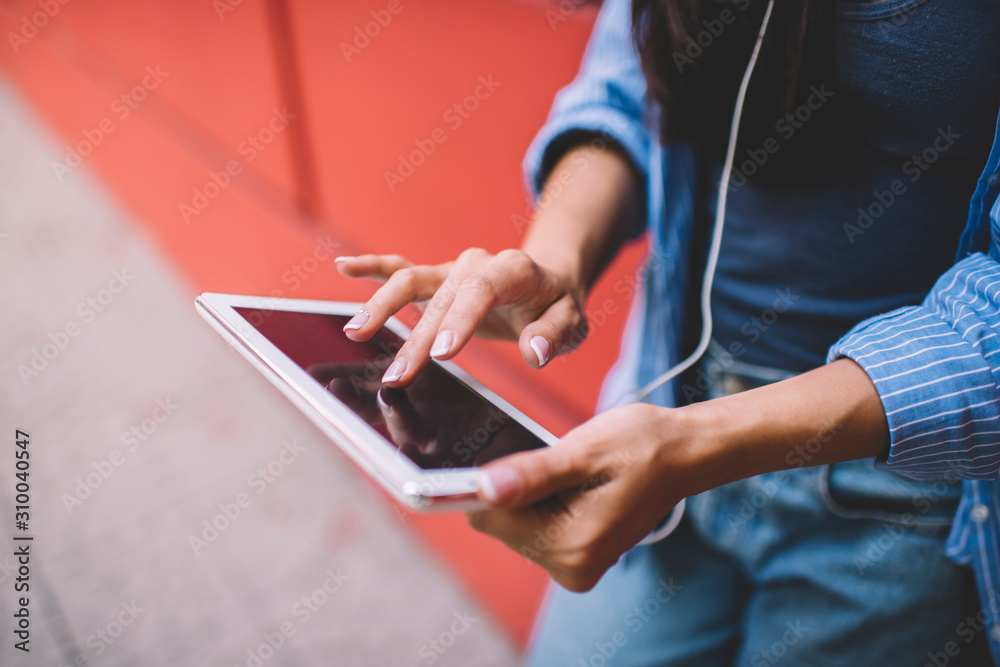 Cropped image of millennial woman using touch pad app during leisure time for communication in web networks connected to 4g wireless for surfing internet, selective focus on digital tablet