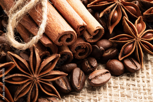 Cinnamon and anise on the background of coffee beans and burlap. © Vladyslav