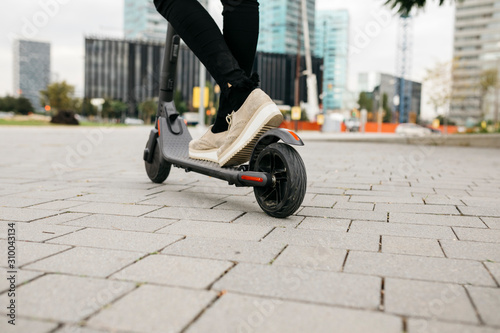 Young businesswoman with e-scooter in the city