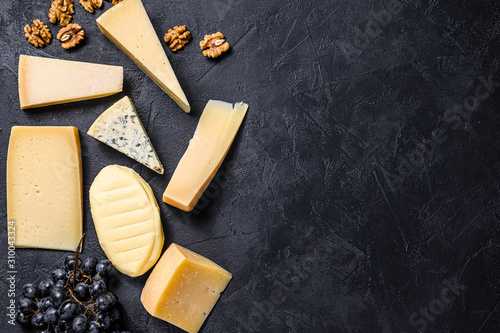 Different types of delicious cheese. Black background. Top view. Space for text
