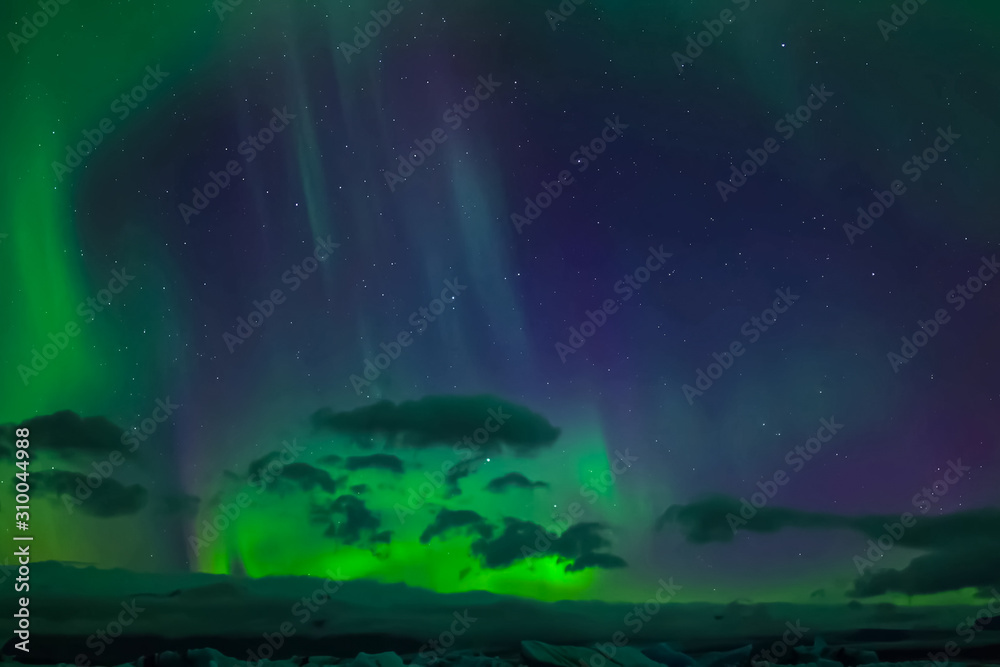 Aurora borealis in night northern sky. Ionization of air particles in the upper atmosphere.