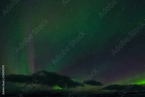 Aurora borealis in night northern sky. Ionization of air particles in the upper atmosphere.