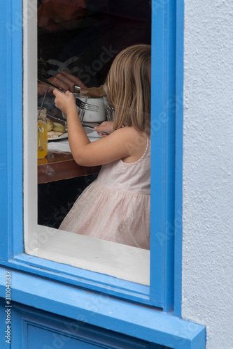 Fototapeta Naklejka Na Ścianę i Meble -  Girl eating breakfast at cafe, Kinsale, County Cork, Ireland