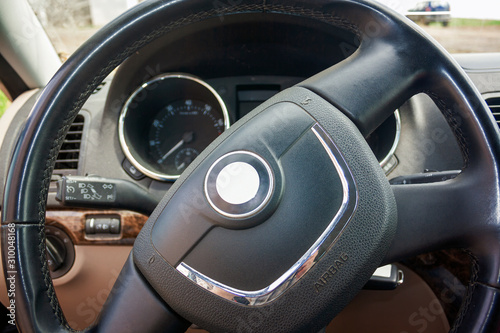 Steering wheel of a passenger car close-up. View of the interior of a modern automobile showing the dashboard. © Anatoliy