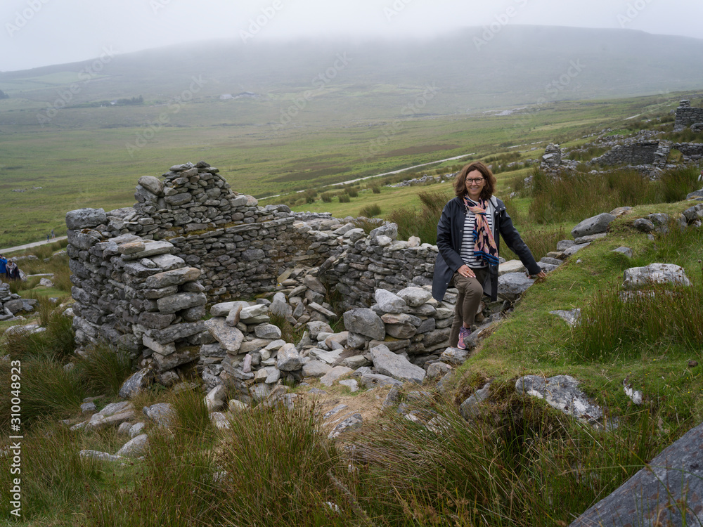 Women standing on the ruins of deserted village, Achill Island, County Mayo, Ireland