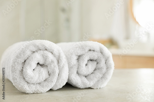 Clean rolled towels on table in bathroom